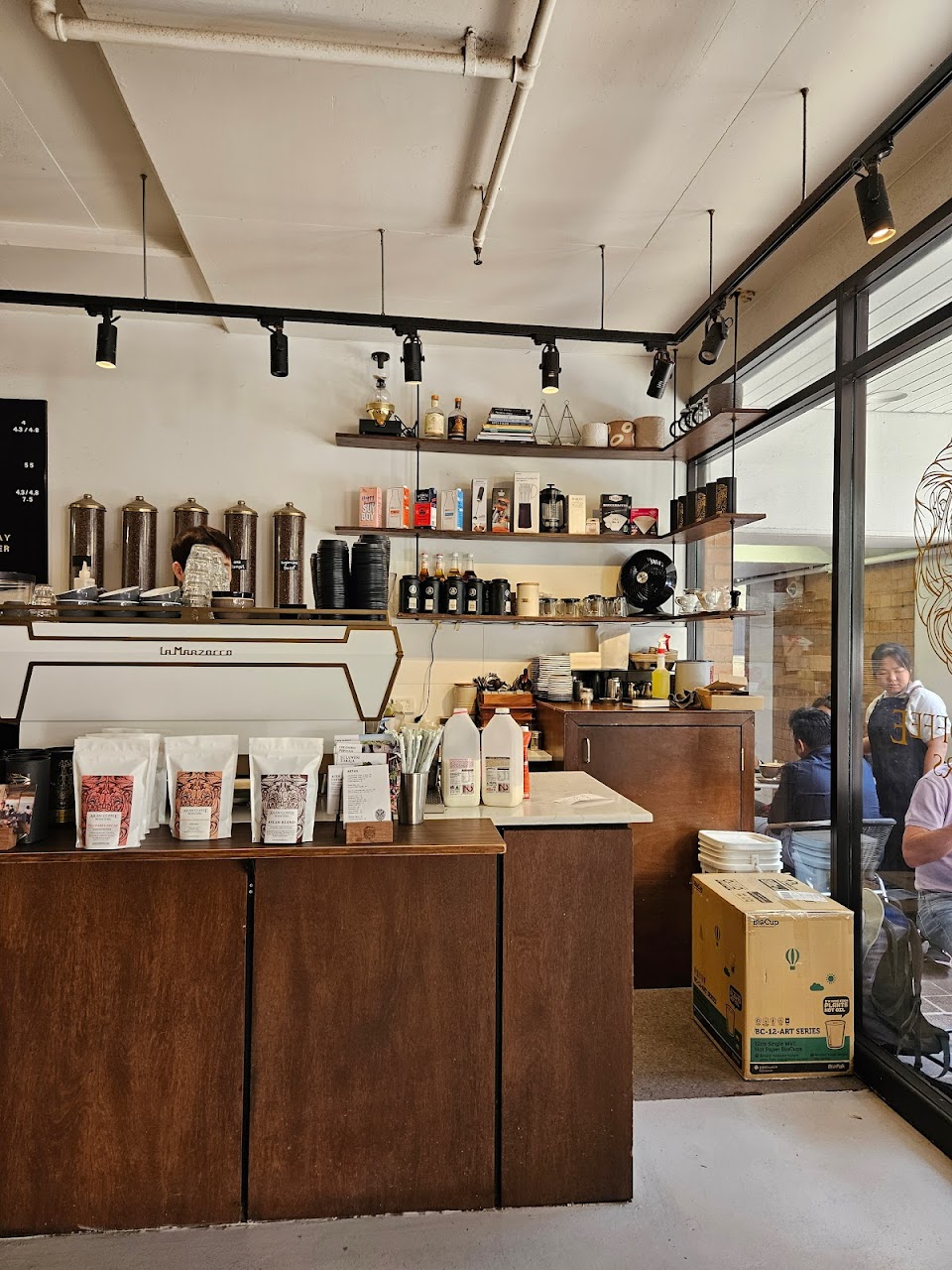 ASLAN espresso bar with coffee bags, machine, and counter